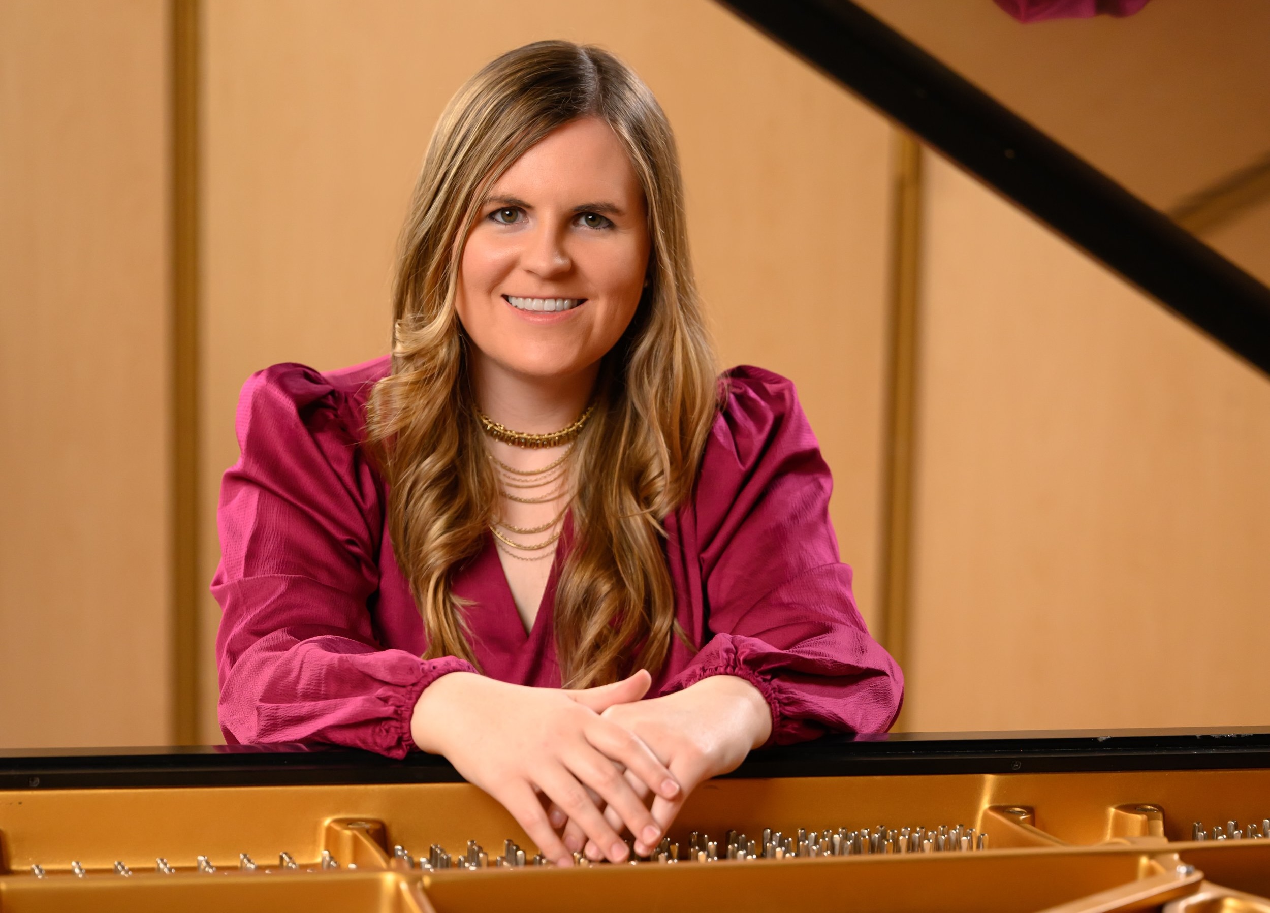 Benson Headshot Piano A man posing by the piano.